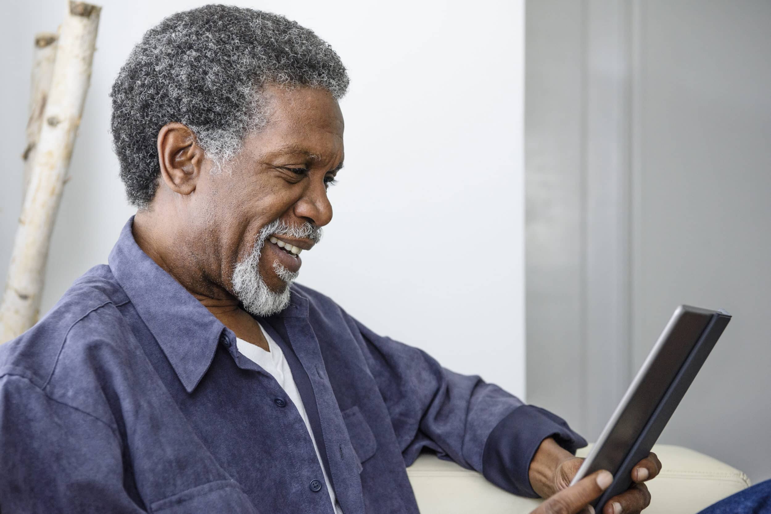 Senior African American man using digital tablet, smiling Senior African American man using digital tablet, smiling