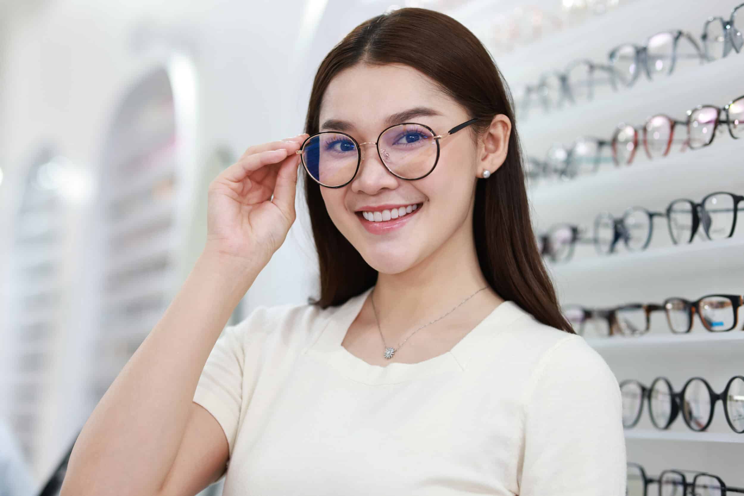 Beautiful young woman choosing eyeglasses frame in an optical store. Beautiful young woman choosing eyeglasses frame in an optical store.